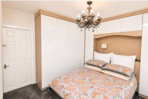 a bedroom with a bed and a chandelier at Lennon cottage in Hale