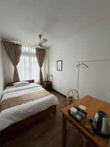 a bedroom with a bed and a table and a window at Kesang Stay in Diphu +22 photos