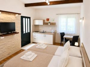 a living room with a large bed and a kitchen at Guest House Ankora in Skradin