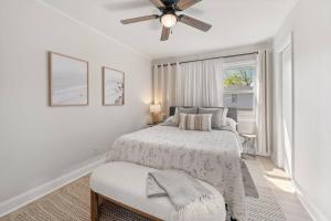 a white bedroom with a bed and a ceiling fan at Bradley Beach Compound in Bradley Beach