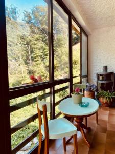 a room with a table and chairs and a large window at MULINO DELLA VALLE in Cittiglio