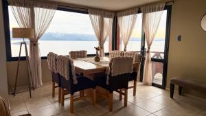 a dining room with a table and a large window at Catalonia Sur Aparts in San Carlos de Bariloche