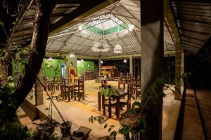 a restaurant with tables and chairs in a building at Vihanga Village - Jungle retreat in Dambulla in Dambulla