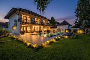 a house with a swimming pool at night at Eden Villa A Tropical Paradise Pool Villa in Rawai Beach