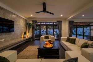 a living room with a couch and a ceiling fan at Eden Villa A Tropical Paradise Pool Villa in Rawai Beach