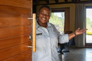 a man is standing next to a wooden door at Addo Elephant Safari Lodge - Bellevue Forest Reserve in Paterson