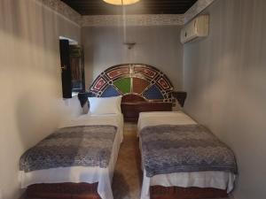 a room with two beds in a room at Palais Doha & SPA in Fez