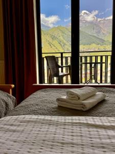 a bedroom with a bed with a view of a mountain at Aronia Kazbegi in Kazbegi