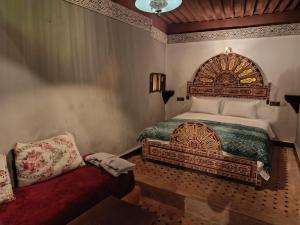 a bedroom with a large bed and a couch at Palais Doha & SPA in Fez