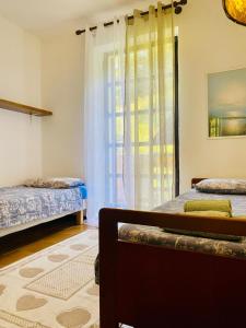 a bedroom with two beds and a window at MULINO DELLA VALLE in Cittiglio