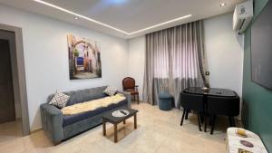 a living room with a couch and a piano at Luxe appartement Khezama est in La Corniche