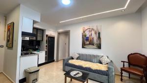 a living room with a blue couch and a kitchen at Luxe appartement Khezama est in La Corniche