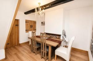 a dining room with a wooden table and chairs at Lennon cottage in Hale