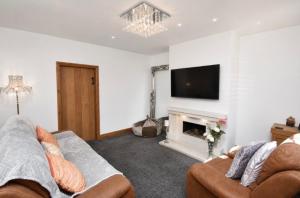 a living room with a couch and a fireplace at Lennon cottage in Hale