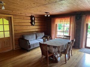 a dining room with a table and a couch at Pakrasti in Svente