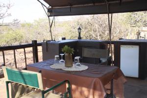 a table and chairs on a screened porch with a table and chairs at Kunkura Game Lodge & Conference Centre in Modimolle