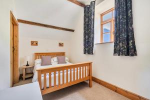 ein Schlafzimmer mit Kinderbett und Fenster in der Unterkunft Hay Store in Corwen