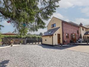 an exterior view of a house with a gravel driveway at Ash Farm Cottage in Holywell