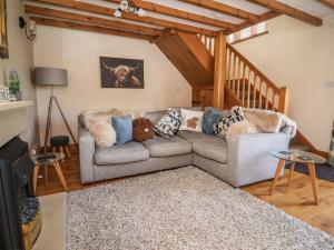 a living room with a couch and a staircase at Ash Farm Cottage in Holywell