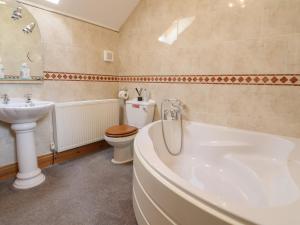 a bathroom with a tub and a toilet and a sink at Ash Farm Cottage in Holywell +27 photos