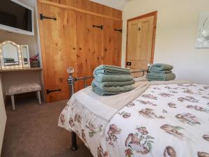 a bedroom with a bed with towels on it at Ash Farm Cottage in Holywell