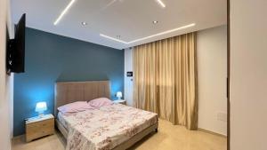 a bedroom with a bed and a blue wall at Superbe appartement Khezama in La Corniche