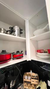 a kitchen shelf with pots and pans on it at Superbe appartement Khezama in La Corniche +19 photos