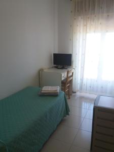 a bedroom with a bed and a desk with a computer at Albergo Villa Nobile in Chiaramonte Gulfi