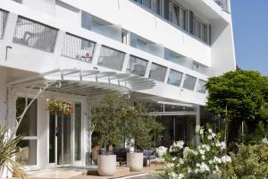 an external view of a white building with plants at Hotel Maison Forge - Ex Hotel ASTORIA- Saint Etienne-Centre des Congrès- in Saint-Étienne