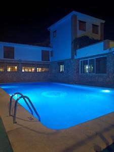 a swimming pool lit up at night with a slide at Hotel Spa Venta Ticiano in Yeste