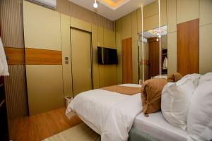 a hotel room with a bed and a mirror at IGAWILO RESIDENCE Hotel in Dodoma