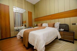 a bedroom with a large bed and a mirror at IGAWILO RESIDENCE Hotel in Dodoma