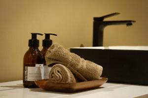 a bathroom with two bottles of soap and a towel at Addo Elephant Safari Lodge - Bellevue Forest Reserve in Paterson +71 photos