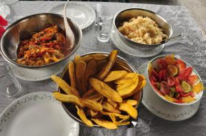 a table with three bowls of food and french fries at Cabaña Perla del Cabo in Nuquí