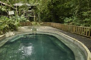 a large pool of water with a wooden fence at Cabaña Perla del Cabo in Nuquí