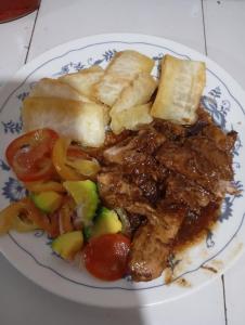 a plate of food with meat and vegetables on a table at Cabaña Perla del Cabo in Nuquí