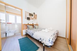 a small bedroom with a bed and a mirror at Pátio Mariano in Serra de El-Rei