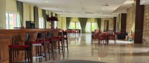 a restaurant with a bar with chairs and tables at Palace Hotel & Spa Termas de São Tiago in Penamacor