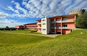 a building with a grassy field in front of it at Palace Hotel & Spa Termas de São Tiago in Penamacor