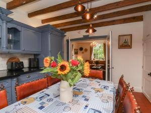 a kitchen with a table with a vase of flowers on it at Reighton House in Filey