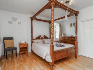 a bedroom with a canopy bed and a chair at Reighton House in Filey