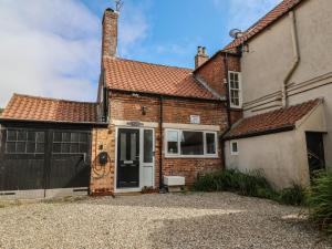 a brick house with a garage and a driveway at Reighton House in Filey