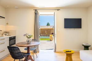 a kitchen and living room with a table and chairs at Domaine Croix-Maro in Caux