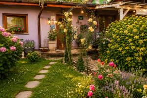 a garden with flowers in front of a house at ROSE ROOM for 4 guests in green Rose resort Ljubljana in Ljubljana
