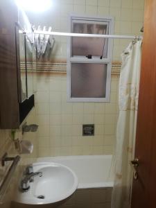 a bathroom with a sink and a tub and a window at Centro Obelisco in Buenos Aires
