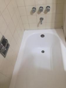 a white bath tub in a bathroom with two faucets at Centro Obelisco in Buenos Aires