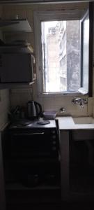 a kitchen with a sink and a stove and a window at Centro Obelisco in Buenos Aires