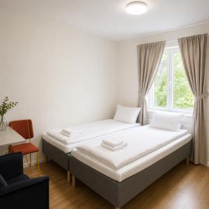 a white bedroom with a bed and a window at Bokloster Longstay in Märsta