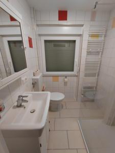 a white bathroom with a sink and a toilet at Ferienwohnung Barthel in Merzig +22 photos