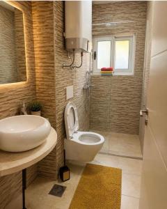a bathroom with a toilet and a sink and a shower at Sun House in Kumbor